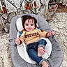 baby, child, infant, smiling, happy, portrait, indoors, high_chair, seated, casual_clothing, jeans, shirt, dark_hair, face, hand, feet, rug, chair, floral_pattern, home_decor