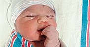 Miran is registered to the contest to win money with this photo: baby, blanket, close_up, cozy, face, fist, hand, hat, hospital, indoors, infant, newborn, nursery, peaceful, photography, portrait, sleeping, striped_clothing, swaddled, yawning
