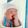 Miran is registered to the contest to win money with this photo: newborn, baby, infant, sleeping, yawning, swaddled, blanket, hat, striped_clothing, hospital, nursery, portrait, close_up, face, hand, fist, peaceful, cozy, indoors, photography