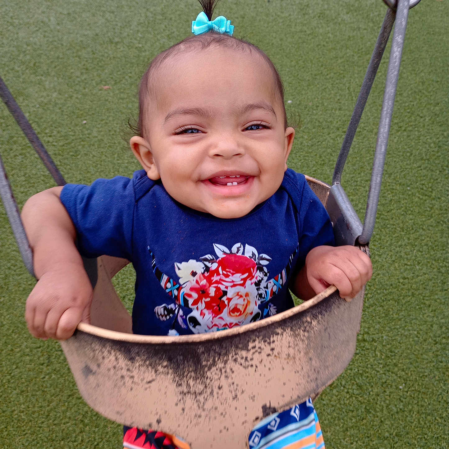 Emerie is registered to the contest to win money with this photo: baby, clothing, face, grass, happy, head, laughing, nature, outdoorplayarea, outdoors, park, person, photography, plant, playarea, portrait, shorts, smile, swing, toy