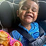 Cohen is registered to the contest to win money with this photo: child, smiling, car_seat, seatbelt, donut, sprinkles, snack, happy, closeup, face, teeth, blue_shirt, buckle, hair, window, inside_car, cheeky_grin, candid_photography, messy_eater, seat_headrest