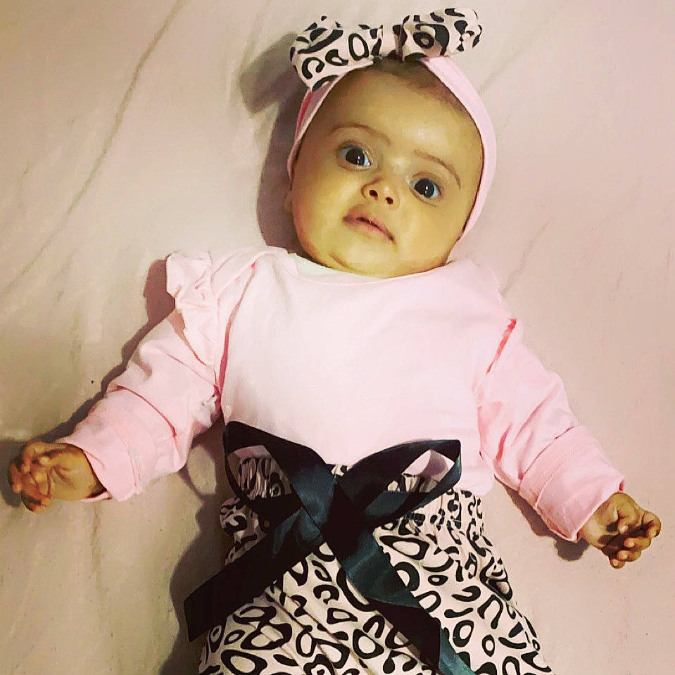 Adley is registered to the contest to win money with this photo: baby, baby_products, baby_toddler_clothing, cheek, child, doll, eye, eyelash, face, fashion_accessory, gesture, happy, head, iris, lip, pattern, person, pink, sleeve, t_shirt