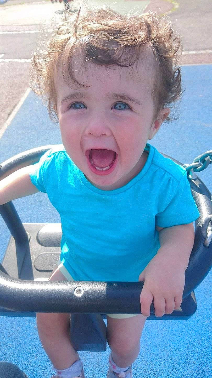 Clarissa Rose is registered to the contest to win money with this photo: baby, child, face, facial_expression, fun, laugh, nose, outdoor_play_equipment, person, play, playground, product, public_space, recreation, skin, smile, summer, swing, toddler, vacation