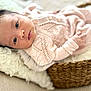baby, infant, basket, blanket, knitted_clothing, pink, soft_texture, face, eyes, lying_down, cozy, indoor, portrait, cute, newborn, child, fabric, woven, peaceful, closeup
