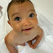 Jade participe au concours pour gagner de l'argent avec cette photo : baby, child, naked, smile, face, eyes, skin, curious, sitting, indoors, white_sheet, wall, expression, infant, head, portrait, cute, looking_up, happy, young