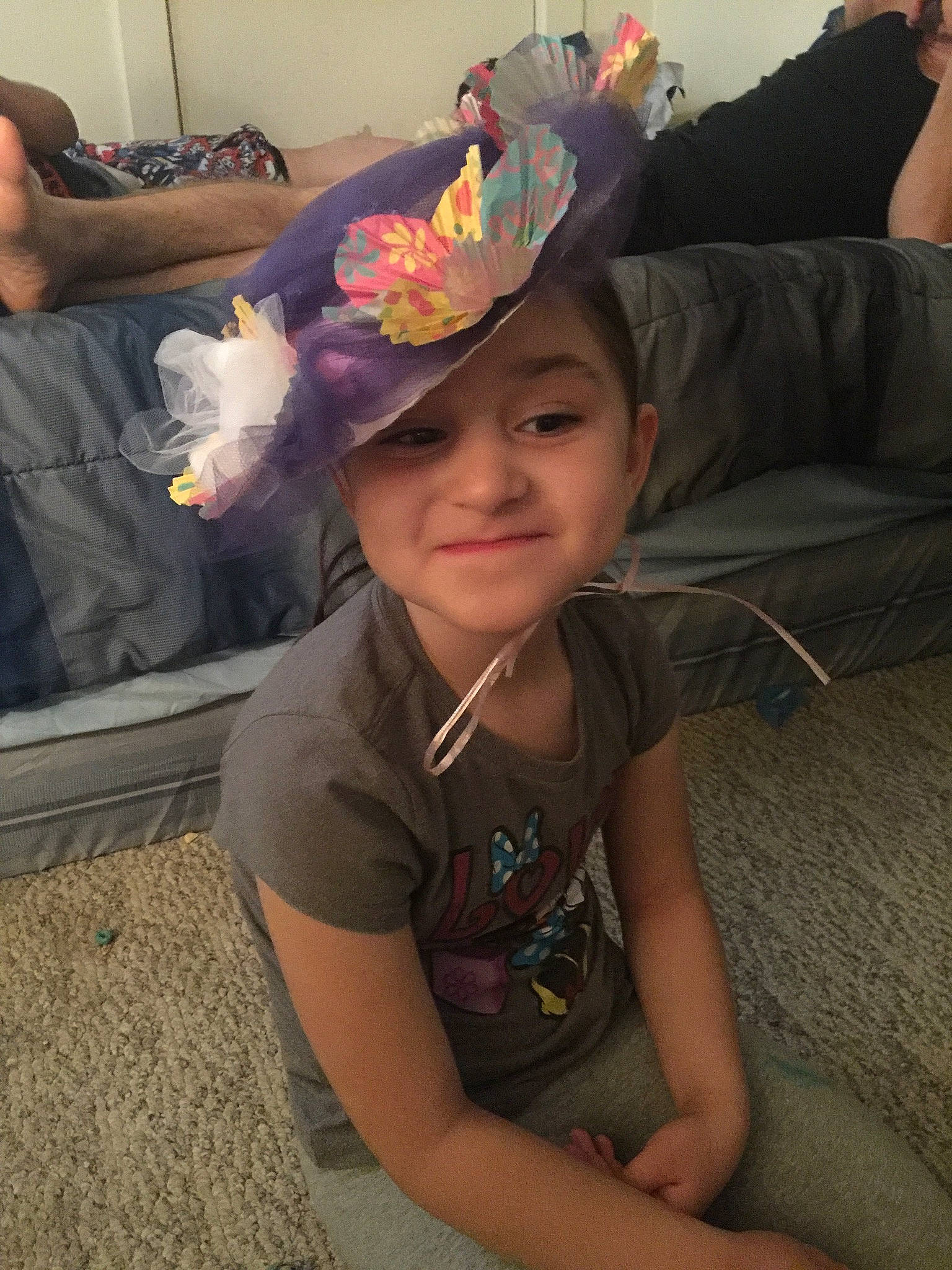 Rosie is registered to the contest to win money with this photo: cap, child, comfort, cool, finger, flooring, fun, happy, headwear, human_body, human_leg, joy, leg, mouth, person, purple, room, sitting, skin, smile