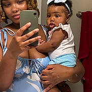 Laiyomi is registered to the contest to win money with this photo: woman, baby, mirror, selfie, bathroom, towel, phone, headband, clothing, person, portrait, holding, reflection, sink, hand, hair, face, smile, cute, indoor