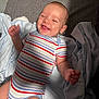 Houston is registered to the contest to win money with this photo: arm, baby, blanket, child, clothing, cozy, cute, gray_surface, hand, happy, head, indoors, infant, lying_down, portrait, skin, smiling, soft_light, striped_onesie, toddler
