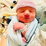 Houston is registered to the contest to win money with this photo: newborn, baby, swaddled, blanket, hat, sleeping, infant, hospital, wristband, person, closeup, soft_lighting, peaceful, cozy, resting, cute, human, portrait, child, wrapped