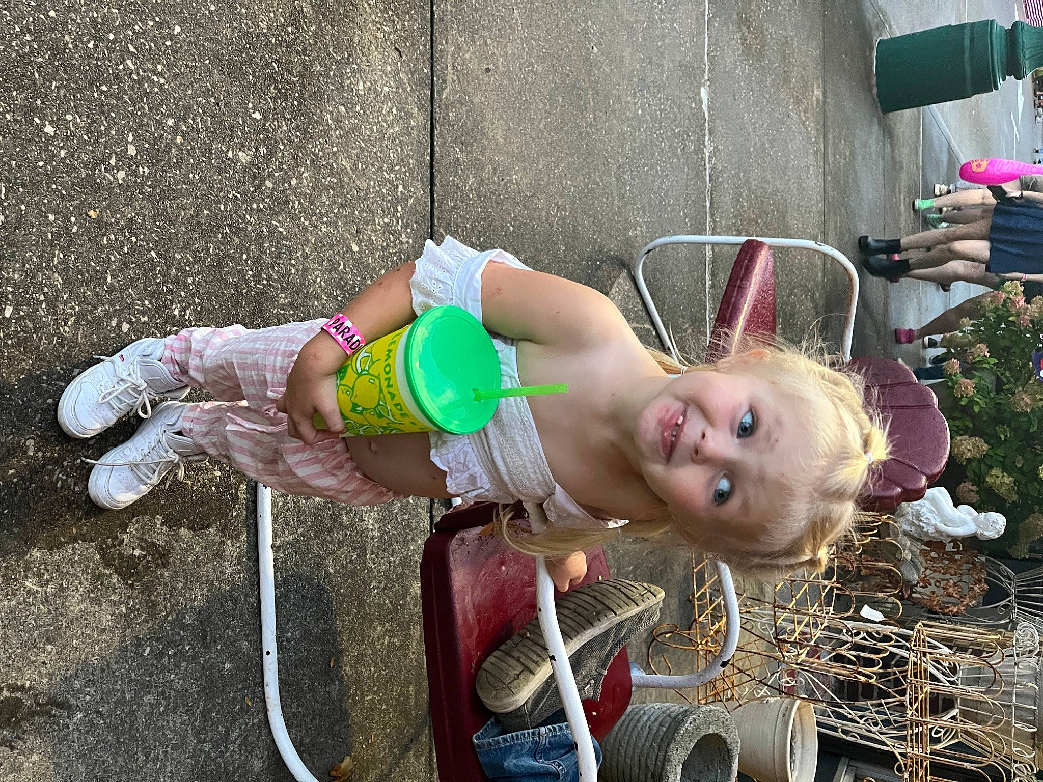 Karter is registered to the contest to win money with this photo: child, concrete, fun, grass, human_leg, joy, leisure, person, plant, recreation, sandal, shorts, sidewalk, sitting, soil, swimwear, thigh, tire, toddler, tree