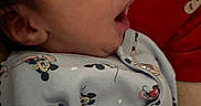 Arlo joined the competition — help win amazing prizes! baby, infant, sleepy, yawning, mickey_mouse, onesie, clothing, cute, person, portrait, indoor, child, face, head, red_background, patterned_clothing, newborn, small, human, cozy