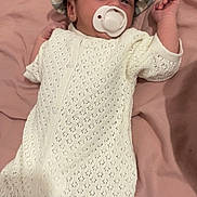 Arlo is registered to the contest to win money with this photo: baby, infant, pacifier, hat, knitted_clothing, white_outfit, pink_blanket, lying_down, cute, newborn, sleepy, child, soft_texture, striped_hat, relaxing, small_hands, cozy, indoors, portrait, peaceful