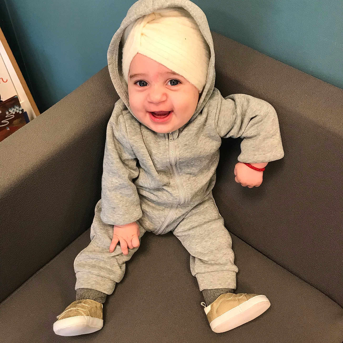 Kim a rejoint le concours — aidez-le/la à gagner de superbes lots ! baby, casual_wear, chair, child, cozy, cute, footwear, grey_clothing, happy, headwrap, hoodie, indoor, infant, person, portrait, shoes, sitting, small_hands, smiling, young_child