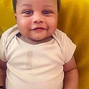 Hamza participe au concours pour gagner de l'argent avec cette photo : baby, infant, smiling, onesie, drool, yellow_pillow, curly_hair, cute, chubby, indoor, portrait, child, happy, sitting, skin, face, hand, young, closeup, cozy