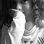 child, curly_hair, black_and_white, portrait, face, hand, sleeve, shirt, expression, young, looking, indoors, closeup, person, cute, smile, hair, monochrome, childhood, casual