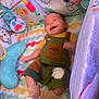 baby, smiling, totoro, overalls, play_mat, toy, colorful, animal_illustrations, infant, socks, happy, cute, child, indoor, soft_toys, patterned, lying_down, small_child, fabric, comfortable