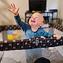 Ezekiel is registered to the contest to win money with this photo: child, toddler, playpen, smiling, happy, pajamas, indoor, baby, hand, reaching, face, person, furniture, blurred_background, home, joy, cute, infant, standing, bright