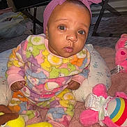 Kamora is registered to the contest to win money with this photo: baby, child, pink_headband, plush_toys, colorful_clothing, indoor, carpet, cute, sitting, curious, infant, soft_toys, patterned_outfit, headwear, young_child, playtime, floor_seating, bright_colors, cozy, portrait