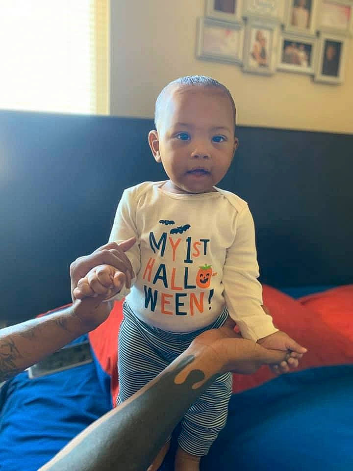 Marcello is registered to the contest to win money with this photo: arm, baby, cheek, child, eye, face, fun, furniture, head, joint, leg, leisure, person, play, room, sitting, skin, smile, t_shirt, toddler