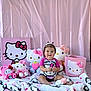 baby, child, hello_kitty, plush_toys, pink, smiling, sitting, blanket, stuffed_animals, cute, portrait, indoor, decor, toy, person, head, clothing, hair_ties, basket, happy