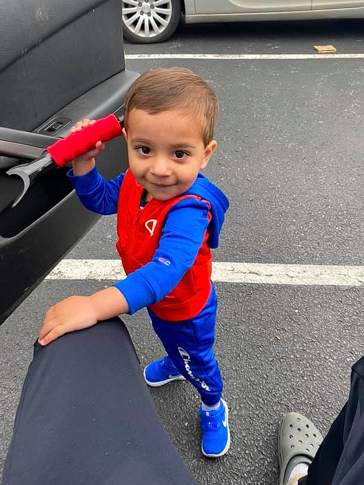 Houston joined the competition — help win amazing prizes! asphalt, automotive_design, automotive_exterior, automotive_lighting, automotive_tire, blue, car, electric_blue, hood, joy, motor_vehicle, person, plant, road, shoe, smile, sneakers, tire, toddler, vehicle_door