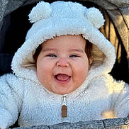 Adhara is registered to the contest to win money with this photo: baby, smiling, hoodie, white_clothing, baby_clothing, happy, face, child, infant, stroller, cute, outdoor, warm_clothing, portrait, baby_face, baby_smile, cozy, soft_texture, baby_boy, baby_girl