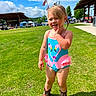 Raelynn is registered to the contest to win money with this photo: child, toddler, girl, outdoor, sunny, grass, portrait, smiling, blonde_hair, braids, swimsuit, colorful_clothing, cowboy_boots, cowgirl, playful, summer, blue_sky, flags, festival, lawn