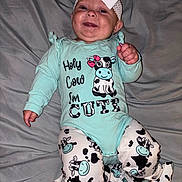 Harper is registered to the contest to win money with this photo: baby, smiling, headband, bow, baby_clothes, onesie, cow_pattern, infant, happy, lying_down, blanket, cute, child, person, foot, hand, indoors, portrait, apparel, fabric
