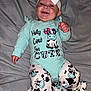 baby, smiling, headband, bow, baby_clothes, onesie, cow_pattern, infant, happy, lying_down, blanket, cute, child, person, foot, hand, indoors, portrait, apparel, fabric