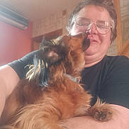 Karine Thibaut a rejoint le concours — aidez-le/la à gagner de superbes lots ! affection, air_conditioner, arm, brown_dog, casual_clothing, close_up, dog, friendly, glasses, happy, home, indoor, long_hair, love, person, pet, smile, tattoo, wall, wooden_stairs