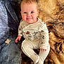 Phoebe is registered to the contest to win money with this photo: baby, child, onesie, mickey_mouse, minnie_mouse, tongue_out, blanket, pacifier, cute, smiling, sitting, infant, clothing, face, head, expression, indoors, soft_texture, playful, person
