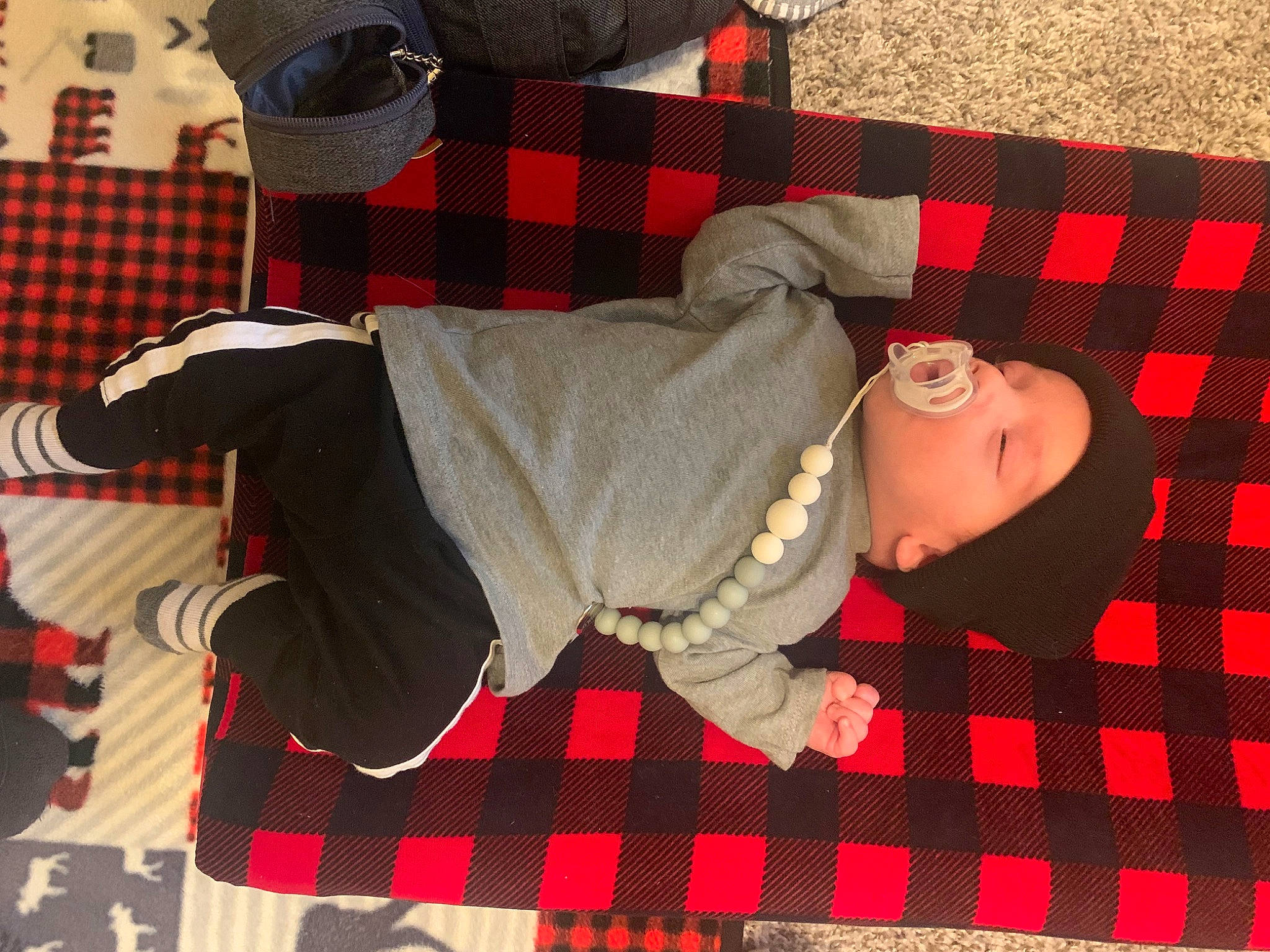 Oaklee joined the competition — help win amazing prizes! baby, baby_toddler_clothing, black, carmine, child, comfort, design, flooring, headwear, linens, pattern, person, plaid, red, sleeve, sock, tartan, textile, thigh, toddler