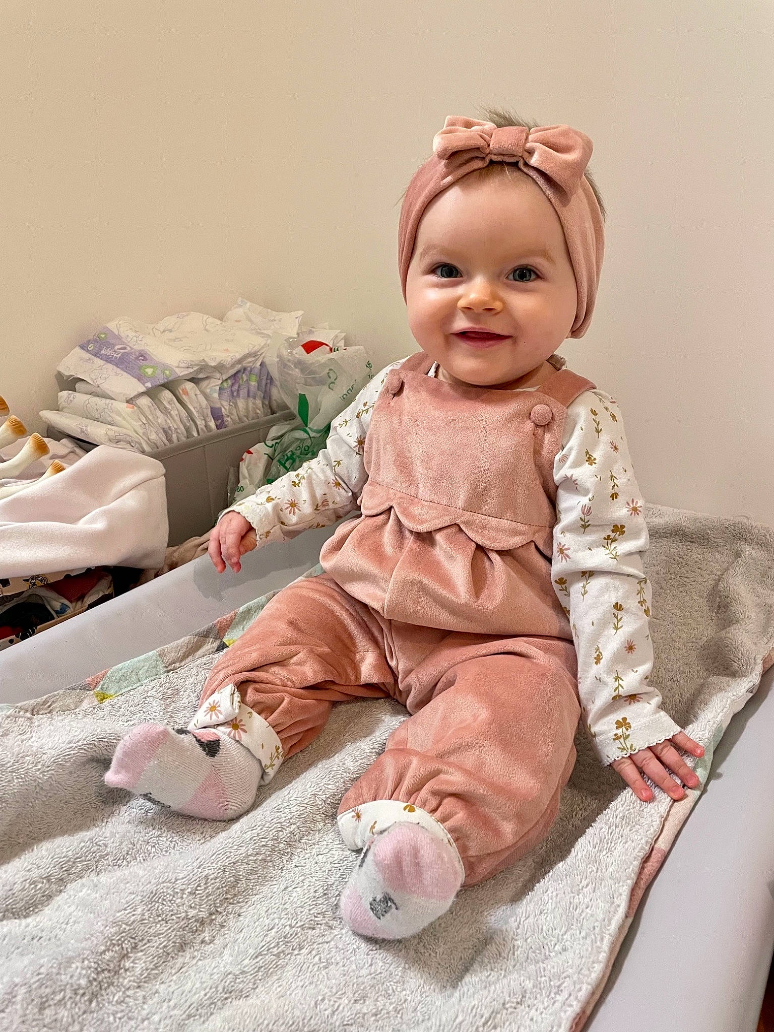 Ambre participe au concours pour gagner de l'argent avec cette photo : baby, baby_products, baby_toddler_clothing, child, comfort, dress, face, flooring, happy, headwear, joy, linens, peach, person, pink, room, sitting, skin, sleeve, smile