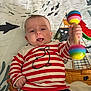 Nathan participe au concours pour gagner de l'argent avec cette photo : baby, infant, playmat, toy, maraca, striped_shirt, whale_print, tongue_out, colorful, playful, lying_down, child, cute, indoors, wooden_floor, pacifier, water_theme, fish, boat, smiling