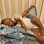 Jaylen is registered to the contest to win money with this photo: toddler, baby, bottle, blanket, crib, bed, sleepwear, child, indoor, pacifier, face, hand, foot, star_pattern, white_clothing, soft_toy, sleeping_area, relaxing, infant, bedding