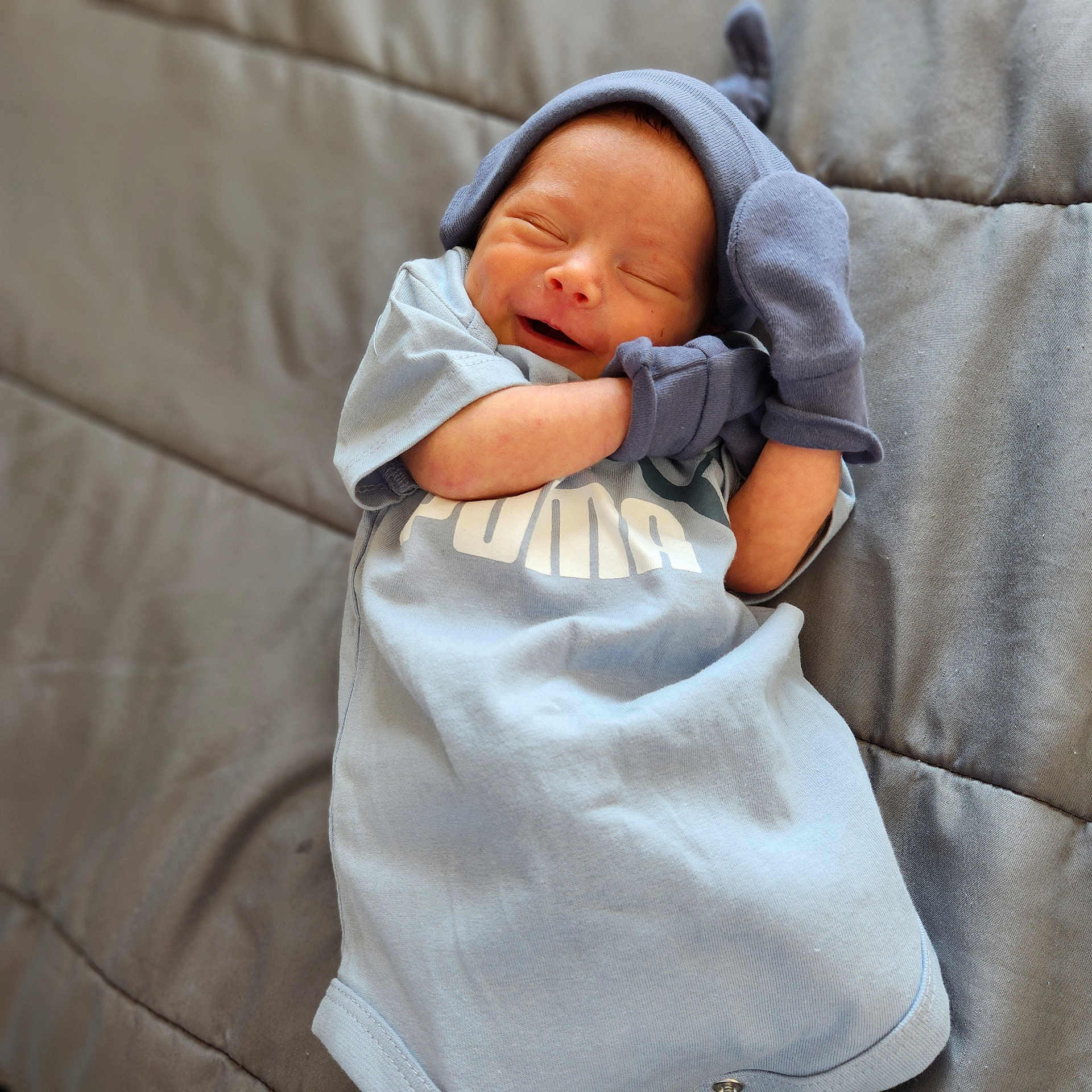 Roman is registered to the contest to win money with this photo: baby, blanket, bodypart, bonnet, clothing, couch, face, furniture, glove, hat, head, hood, hoodie, knitwear, newborn, person, photography, portrait, sweater, sweatshirt