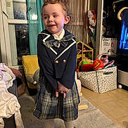 Calysta participe au concours pour gagner de l'argent avec cette photo : child, girl, plaid_skirt, blazer, bow, smile, indoor, carpet, toy_box, toys, cushion, window, curtains, boots, clothing, home, furniture, floor, person, portrait