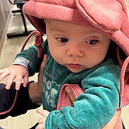 Azur participe au concours pour gagner de l'argent avec cette photo : baby, child, hood, pink, ears, teal_clothing, hands, adult_hand, indoor, curious, face, eyes, soft_lighting, portrait, cute, infant, warm_clothing, closeup, person, expression