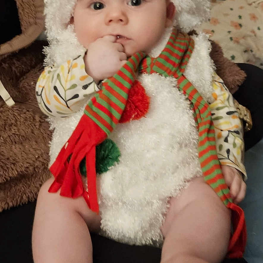 Azur participe au concours pour gagner de l'argent avec cette photo : baby, blanket, child, clothing, costume, cute, eyes, face, feet, furniture, hand, hat, indoor, infant, legs, pillow, portrait, scarf, sitting, snowman