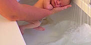 Azur participe au concours pour gagner de l'argent avec cette photo : newborn, baby, bathtub, water, arm, tattoo, shower, bath, person, skin, sleeping, infant, hand, bathroom, relaxation, care, parent, tenderness, cleaning, small
