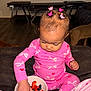 Caríelle is registered to the contest to win money with this photo: toddler, child, pink_pajamas, bow_pattern, heart_pattern, hair_clips, butterfly_clips, fruit_bowl, strawberries, blueberries, indoor, couch, dark_furniture, hand, food, snack_time, cute, focused, sitting, person