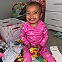Caríelle joined the competition — help win amazing prizes! toddler, child, pink_pajamas, sitting, smiling, indoor, play_mat, toys, clothes, hair_clips, basket, dresser, carpet, window, happy, person, room, cute, baby, playtime