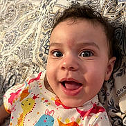 Amelia joined the competition — help win amazing prizes! baby, child, smiling, face, eyes, dinosaur_print, clothing, patterned_blanket, cute, happy, infant, portrait, lying_down, colorful, cheerful, young_child, indoors, baby_girl, apparel, head