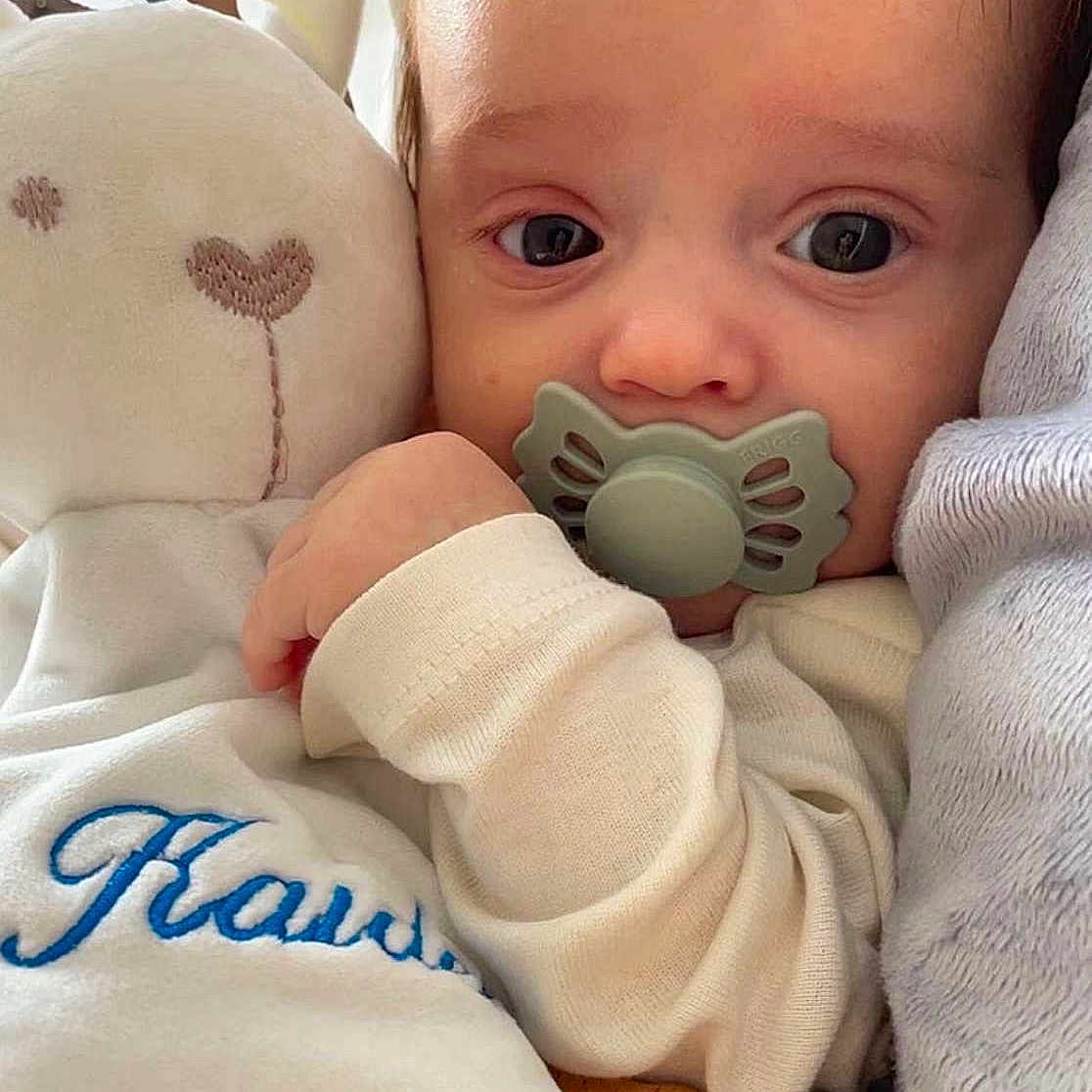 Kaïden a rejoint le concours — aidez-le/la à gagner de superbes lots ! baby, blue_text, child, close_up, comfort, cozy, cuddling, cute, face, hand, indoors, infant, pacifier, phone, plush_toy, portrait, resting, sleepy, soft_texture, white_clothing