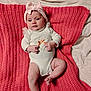baby, infant, headband, bow, blanket, knitted, white_clothing, cute, lying_down, indoors, soft_texture, child, newborn, peaceful, small_hands, small_feet, portrait, person, cozy, pink