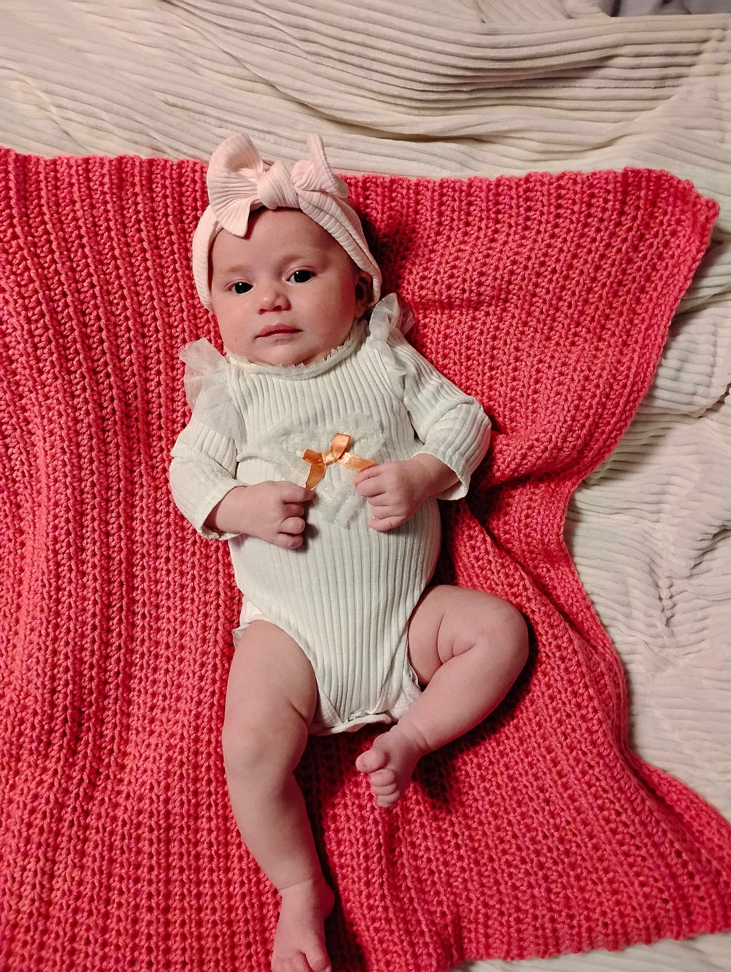 Isabella joined the competition — help win amazing prizes! baby, infant, headband, bow, blanket, knitted, white_clothing, cute, lying_down, indoors, soft_texture, child, newborn, peaceful, small_hands, small_feet, portrait, person, cozy, pink