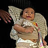 baby, child, infant, lying_down, striped_cloth, winnie_the_pooh, shirt, candy, hand, pink_nails, dark_background, smiling, cute, diaper, pants, person, closeup, happy, indoors, portrait