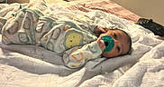 Nazavion joined the competition — help win amazing prizes! animal_print, baby, bed, blanket, carpet, child, cozy, cute, diapers, doorway, flooring, game_controller, home, indoors, infant, onesie, pacifier, resting, sleepwear, soft_lighting