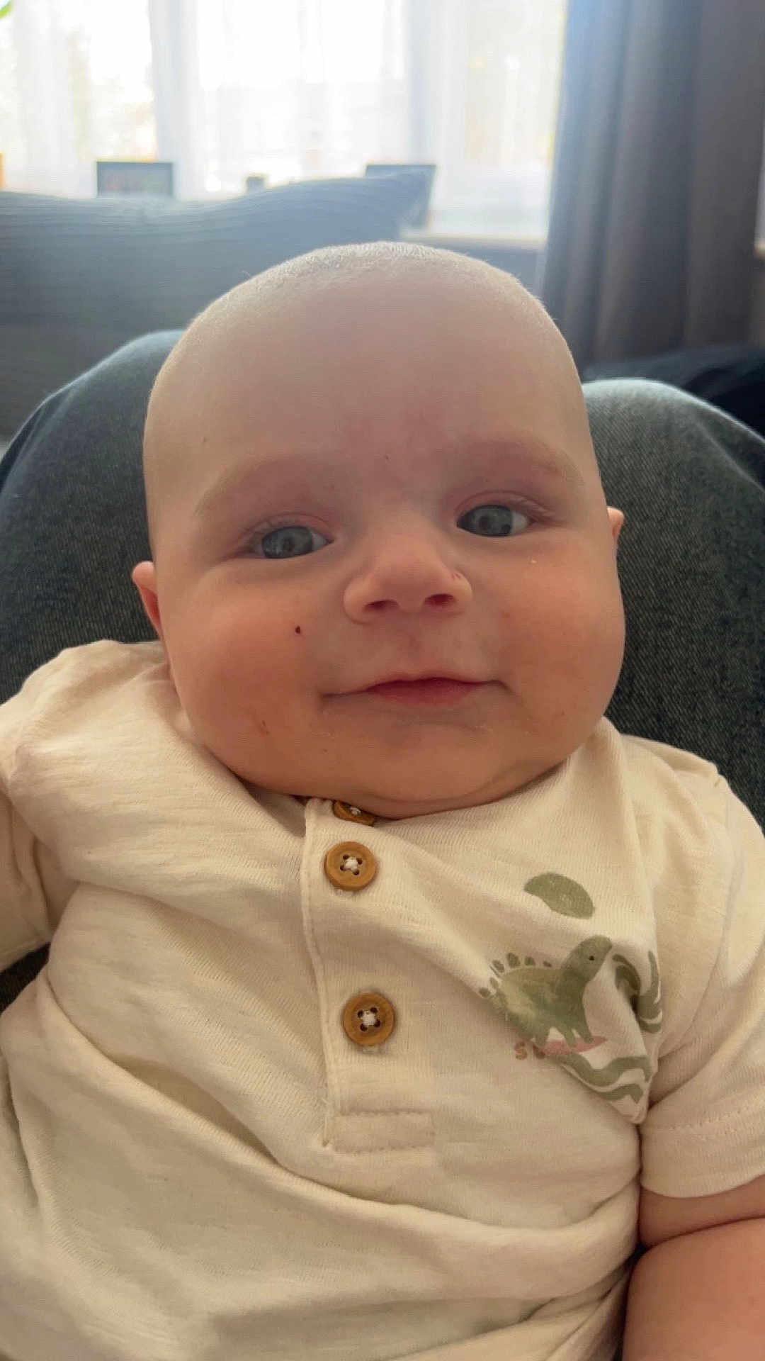 Christopher joined the competition — help win amazing prizes! baby, child, infant, face, smile, eyes, shirt, buttons, dinosaur_print, cute, indoor, portrait, closeup, soft_light, skin, head, chubby_cheeks, person, young_child, comfortable