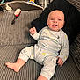 Christopher is registered to the contest to win money with this photo: baby, child, couch, pajamas, smiling, indoor, furniture, pillow, face, person, happy, foot, hand, hairbrush, clothing, living_room, seated, toy, blanket, cozy
